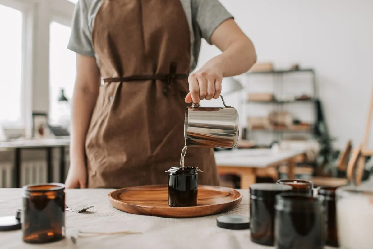 A maker pouring wax into jars; illustrative workshop photograph