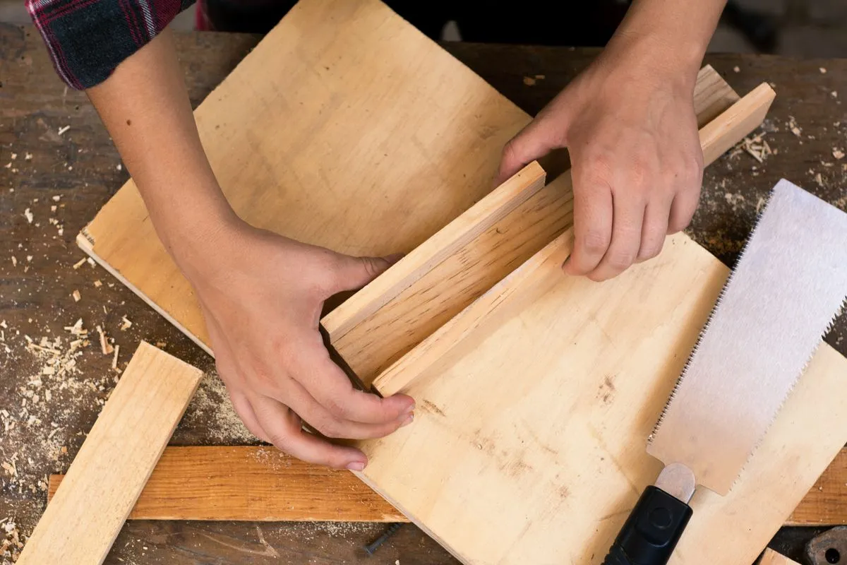 Hands fitting timber at a woodworking bench; illustrative workshop photograph